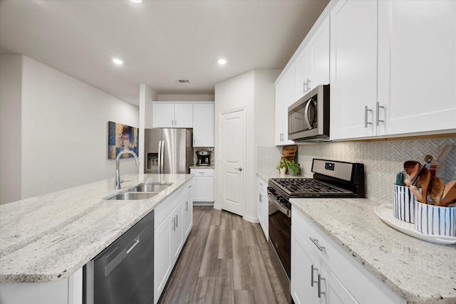 5223 Amistad Ave, Royse City, TX 75189 - kitchen with stainless steel appliances, wood finished floors, tasteful backsplash, white cabinetry, and recessed lighting