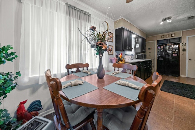 6753 Murphy St, Murchison, TX 75778 - dining area featuring ornamental molding, a textured ceiling, and light tile patterned floors