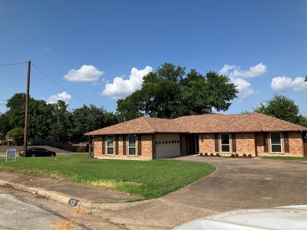 828 N Young Blvd, Desoto, TX 75115 - ranch-style house featuring an attached garage, a front lawn, brick siding, and driveway