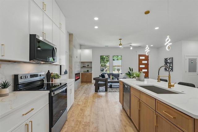 2910 Brigham Ln, Dallas, TX 75215 - kitchen with appliances with stainless steel finishes, a ceiling fan, light wood-style flooring, recessed lighting, and open floor plan