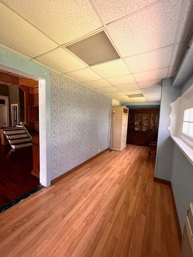 1612 Lagonda Ave, Fort Worth, TX 76164 - unfurnished room featuring wood finished floors, a drop ceiling, and stairway