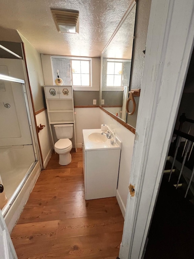1612 Lagonda Ave, Fort Worth, TX 76164 - bathroom featuring a shower stall, wood finished floors, vanity, and a textured ceiling