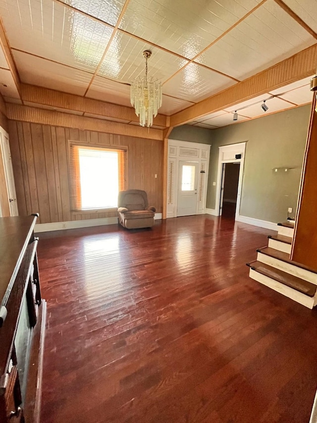1612 Lagonda Ave, Fort Worth, TX 76164 - unfurnished living room featuring a chandelier, wood finished floors, and wooden walls