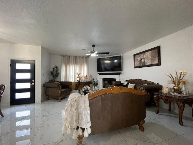 1603 Pacific Ave, Ennis, TX 75119 - living room featuring light marble finish floors, a ceiling fan, and a glass covered fireplace