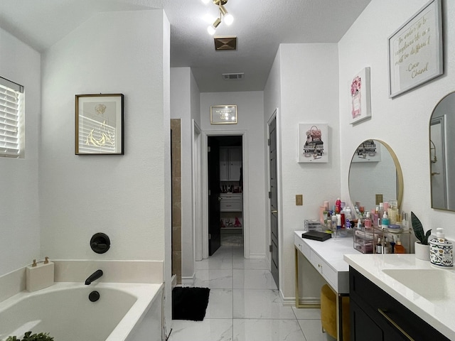 1603 Pacific Ave, Ennis, TX 75119 - bathroom with marble look tiles, vanity, and a garden tub