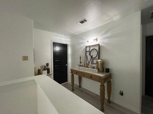 1603 Pacific Ave, Ennis, TX 75119 - hallway with wood finished floors and a textured ceiling