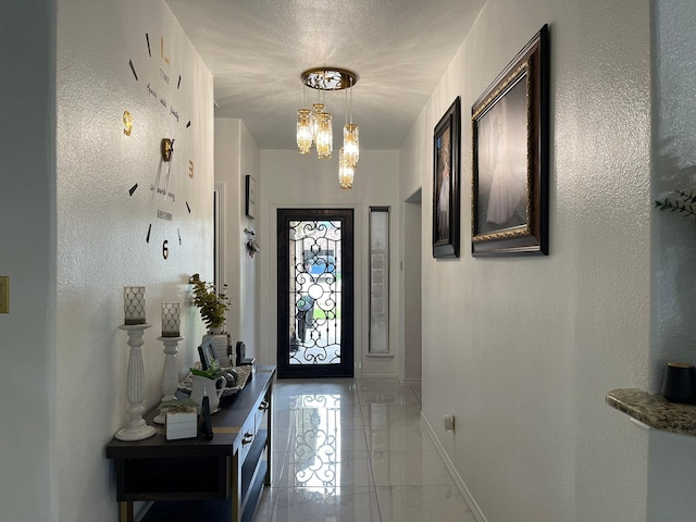 1603 Pacific Ave, Ennis, TX 75119 - foyer with light marble finish flooring, a chandelier, and a textured wall