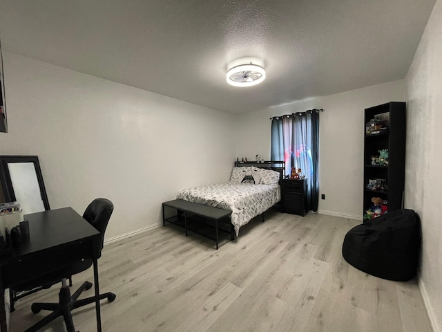 1603 Pacific Ave, Ennis, TX 75119 - bedroom featuring light wood-type flooring, an office area, and a textured ceiling