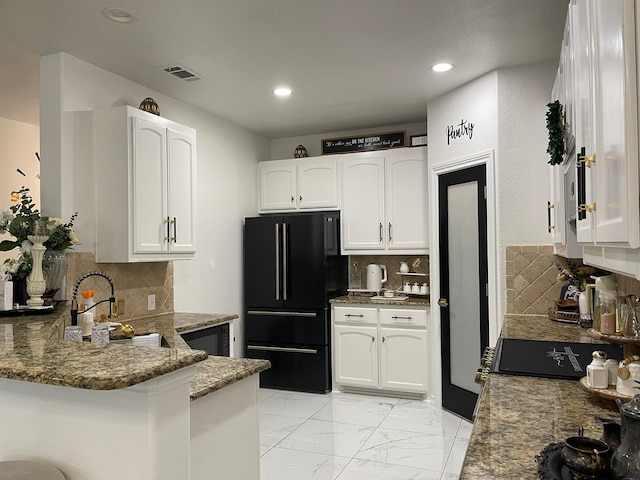 1603 Pacific Ave, Ennis, TX 75119 - kitchen with freestanding refrigerator, stone countertops, a peninsula, white cabinets, and recessed lighting