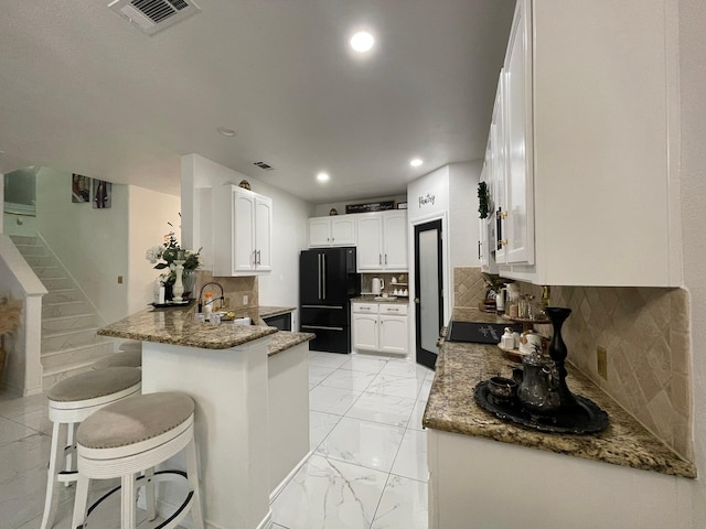 1603 Pacific Ave, Ennis, TX 75119 - kitchen with freestanding refrigerator, a peninsula, recessed lighting, stone counters, and light marble finish floors