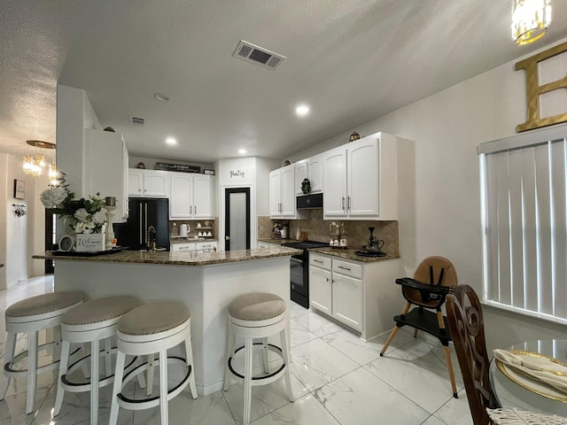 1603 Pacific Ave, Ennis, TX 75119 - kitchen with black appliances, a peninsula, light marble finish floors, dark stone countertops, and a kitchen bar