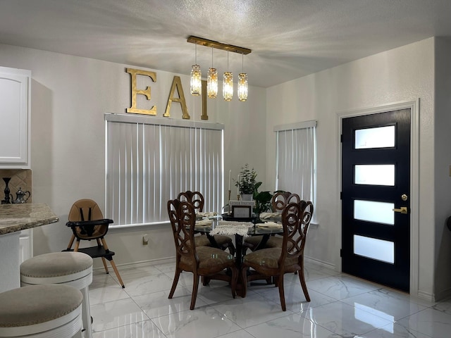 1603 Pacific Ave, Ennis, TX 75119 - dining room featuring light marble finish floors, a chandelier, and a textured ceiling