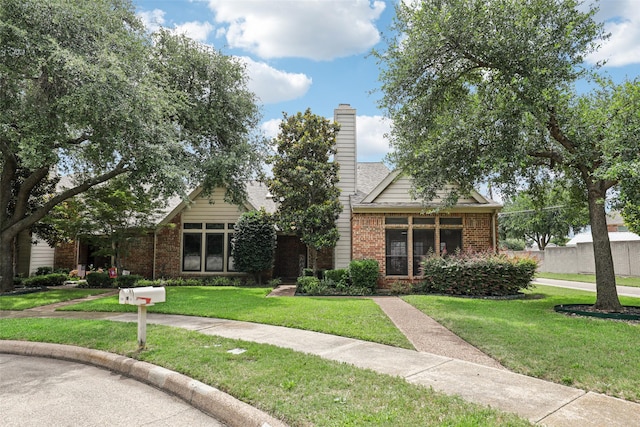 2531 Stanford Ct, Carrollton, TX 75006 - obstructed view of property with brick siding, a front lawn, and a chimney