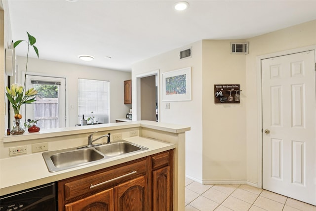 2531 Stanford Ct, Carrollton, TX 75006 - kitchen featuring light countertops, light tile patterned floors, brown cabinets, dishwasher, and recessed lighting