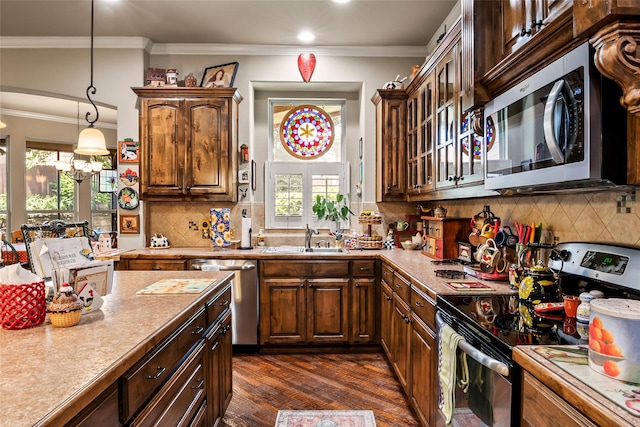 513 Hearth Ter, Argyle, TX 76226 - kitchen with appliances with stainless steel finishes, dark wood-style flooring, crown molding, light countertops, and tasteful backsplash