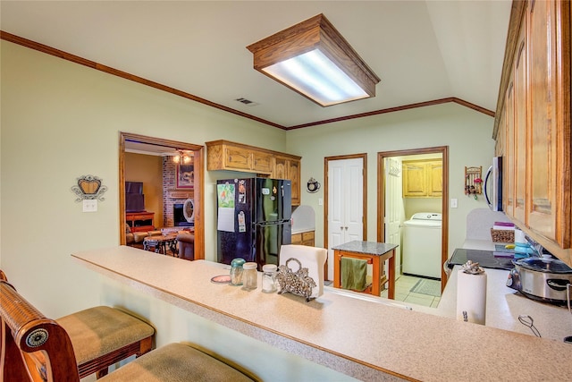 1813 Ranch Rd, Royse City, TX 75189 - kitchen featuring freestanding refrigerator, stainless steel microwave, washer / clothes dryer, a breakfast bar, and crown molding