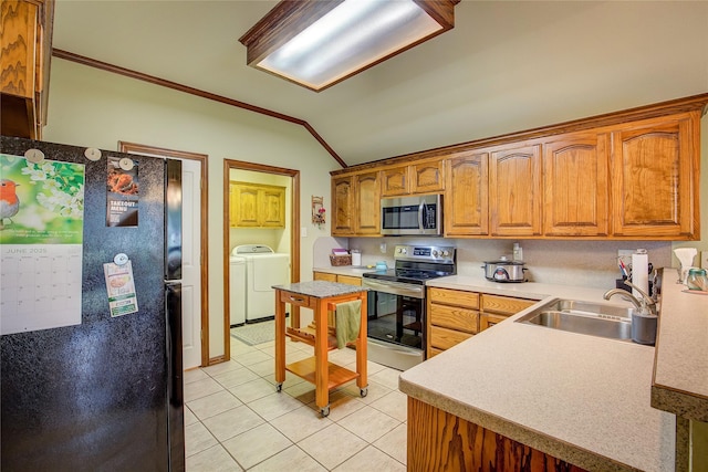 1813 Ranch Rd, Royse City, TX 75189 - kitchen featuring appliances with stainless steel finishes, washer and clothes dryer, ornamental molding, light tile patterned floors, and vaulted ceiling