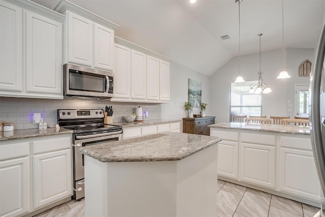 1148 Blue Sky Ln, Burleson, TX 76058 - kitchen with appliances with stainless steel finishes, a kitchen island, vaulted ceiling, tasteful backsplash, and white cabinetry