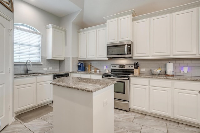 1148 Blue Sky Ln, Burleson, TX 76058 - kitchen with appliances with stainless steel finishes, white cabinets, a center island, and backsplash