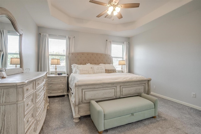 1148 Blue Sky Ln, Burleson, TX 76058 - carpeted bedroom featuring multiple windows, a tray ceiling, and ceiling fan