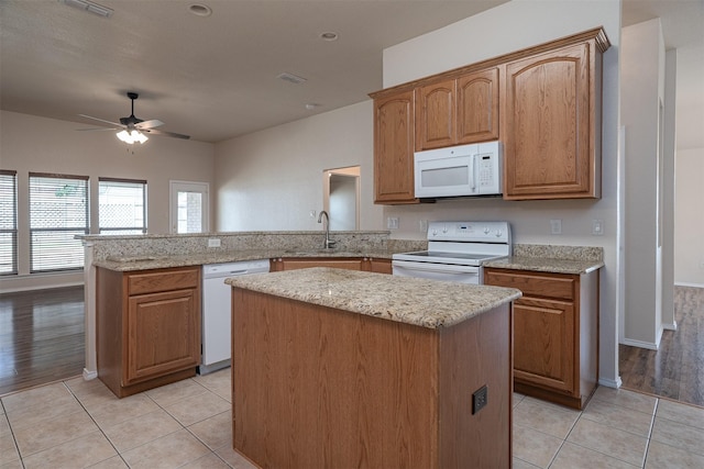 302 Howard Way Dr, Aledo, TX 76008 - kitchen featuring white appliances, a peninsula, a ceiling fan, a center island, and light tile patterned flooring