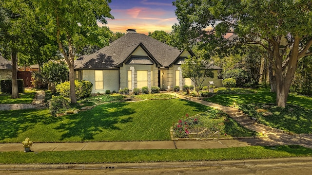 2205 Le Mans Dr, Carrollton, TX 75006 - view of front of property featuring brick siding, a lawn, a shingled roof, and a chimney