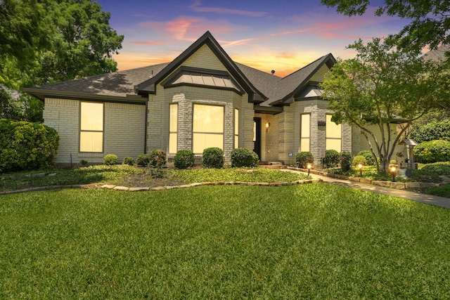 2205 Le Mans Dr, Carrollton, TX 75006 - view of front of home featuring a yard, brick siding, and roof with shingles