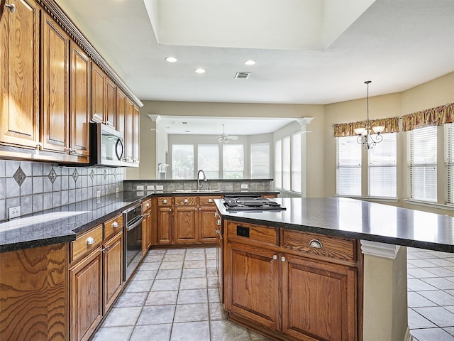 800 Rock Hill Rd, Prosper, TX 75078 - kitchen with stainless steel appliances, recessed lighting, a chandelier, brown cabinetry, and decorative backsplash