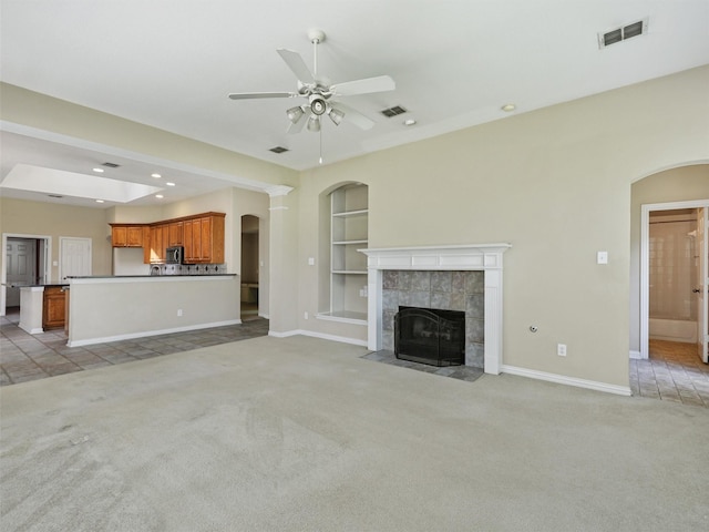 800 Rock Hill Rd, Prosper, TX 75078 - unfurnished living room featuring light carpet, built in shelves, ceiling fan, arched walkways, and recessed lighting