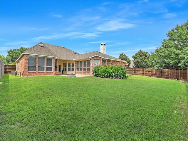 800 Rock Hill Rd, Prosper, TX 75078 - back of house featuring a fenced backyard, brick siding, a sunroom, a chimney, and a shingled roof