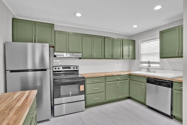 315 Ratcliff, Shreveport, LA 71104 - kitchen with stainless steel appliances, green cabinetry, wood counters, under cabinet range hood, and decorative backsplash