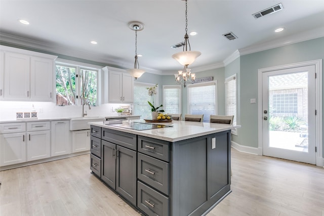 3816 Shady Meadow Dr, Grapevine, TX 76051 - kitchen featuring white cabinets, light wood finished floors, backsplash, a center island, and gray cabinetry