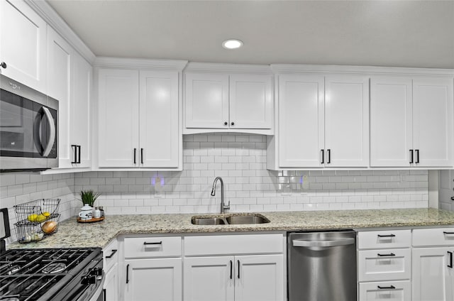 3137 Tex Blvd, Fort Worth, TX 76116 - kitchen featuring appliances with stainless steel finishes, white cabinetry, decorative backsplash, light stone countertops, and recessed lighting