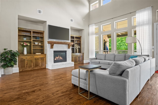 6901 Hickory Hill Cir, Argyle, TX 76226 - living area featuring a towering ceiling, a stone fireplace, and dark wood-type flooring