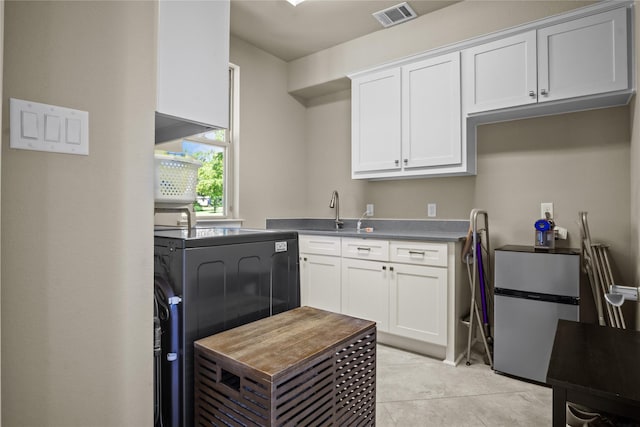 6901 Hickory Hill Cir, Argyle, TX 76226 - kitchen with freestanding refrigerator, white cabinetry, washer / dryer, and dark countertops