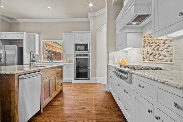 6901 Hickory Hill Cir, Argyle, TX 76226 - kitchen featuring stainless steel appliances, premium range hood, ornamental molding, wood finished floors, and light stone countertops