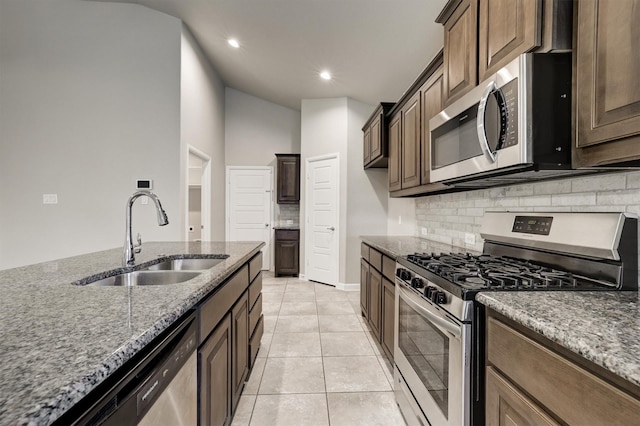 601 Redding Dr, Saginaw, TX 76131 - kitchen with appliances with stainless steel finishes, tasteful backsplash, dark stone counters, recessed lighting, and light tile patterned flooring