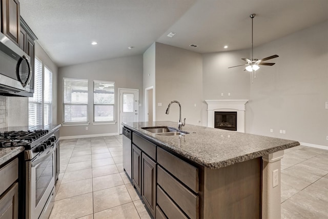 601 Redding Dr, Saginaw, TX 76131 - kitchen featuring appliances with stainless steel finishes, lofted ceiling, light tile patterned flooring, ceiling fan, and an island with sink