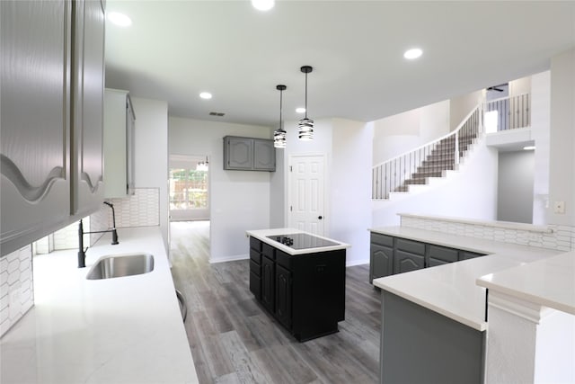 3620 Flintstone Dr, Plano, TX 75074 - kitchen featuring black electric stovetop, wood finished floors, tasteful backsplash, recessed lighting, and a kitchen island