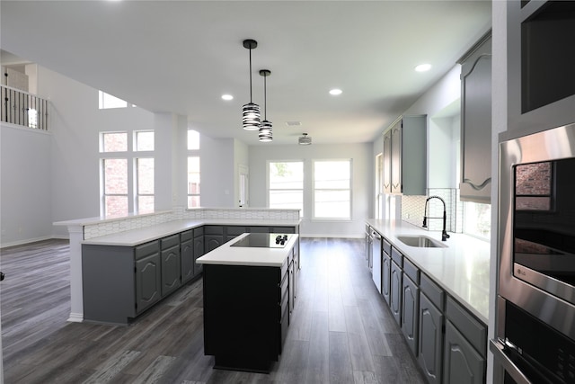 3620 Flintstone Dr, Plano, TX 75074 - kitchen with a kitchen island, black electric cooktop, gray cabinets, dark wood finished floors, and recessed lighting