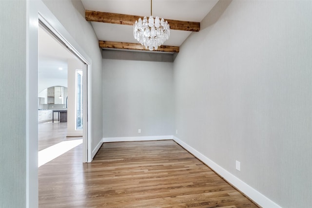 9701 Faircrest Dr, Dallas, TX 75238 - spare room with wood finished floors, beam ceiling, a chandelier, and arched walkways