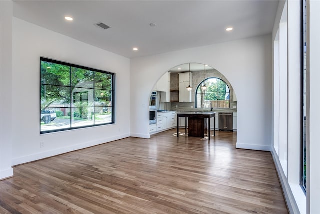 9701 Faircrest Dr, Dallas, TX 75238 - living room with plenty of natural light, light wood-type flooring, arched walkways, and recessed lighting