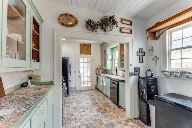 1320 Madeline Pl, Fort Worth, TX 76107 - kitchen with green cabinetry, stainless steel dishwasher, freestanding refrigerator, and plenty of natural light