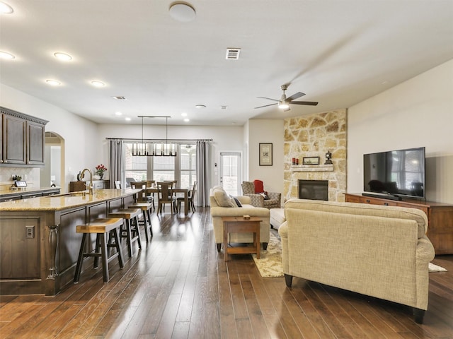 505 Peterhouse Dr, Mckinney, TX 75071 - living room featuring ceiling fan, arched walkways, dark wood-style flooring, a fireplace, and recessed lighting