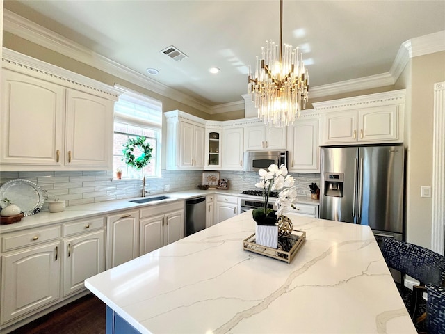 4716 Eva Pl, Plano, TX 75093 - kitchen with stainless steel appliances, crown molding, a chandelier, pendant lighting, and tasteful backsplash