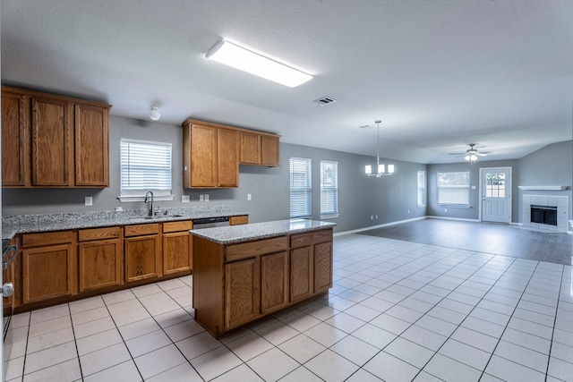 3106 Connor Ln, Wylie, TX 75098 - kitchen featuring brown cabinetry, a chandelier, a fireplace, and open floor plan