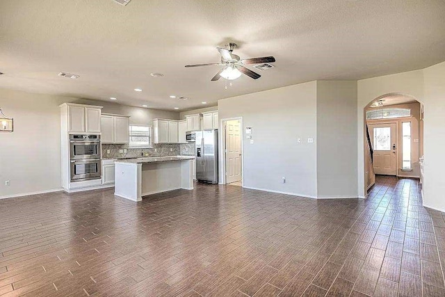 9207 Lake Pointe Dr, Temple, TX 76502 - kitchen featuring stainless steel appliances, open floor plan, dark wood-style flooring, ceiling fan, and a textured ceiling