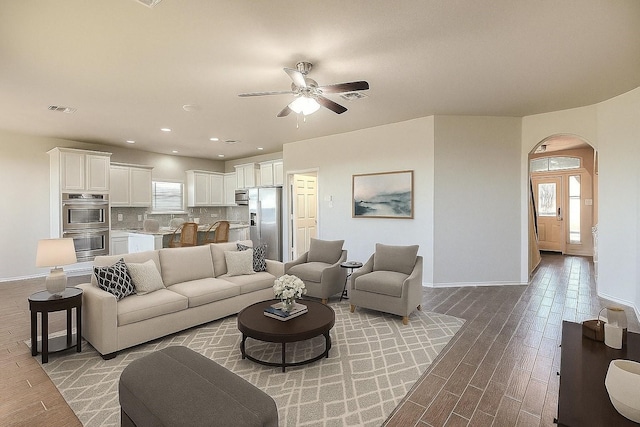 9207 Lake Pointe Dr, Temple, TX 76502 - living area with arched walkways, light wood finished floors, a ceiling fan, and recessed lighting