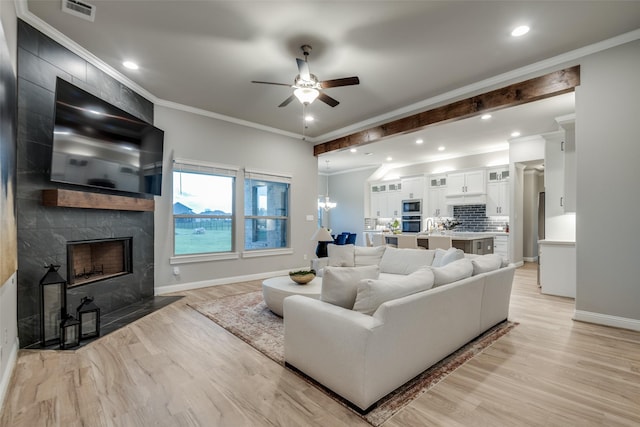 1301 Wilderness Ln, Forney, TX 75126 - living room featuring ceiling fan, light wood-type flooring, a premium fireplace, ornamental molding, and recessed lighting