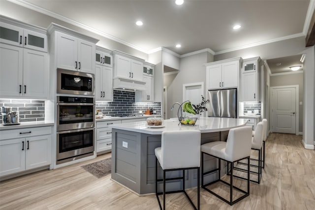 1301 Wilderness Ln, Forney, TX 75126 - kitchen featuring appliances with stainless steel finishes, tasteful backsplash, a breakfast bar area, light countertops, and glass insert cabinets